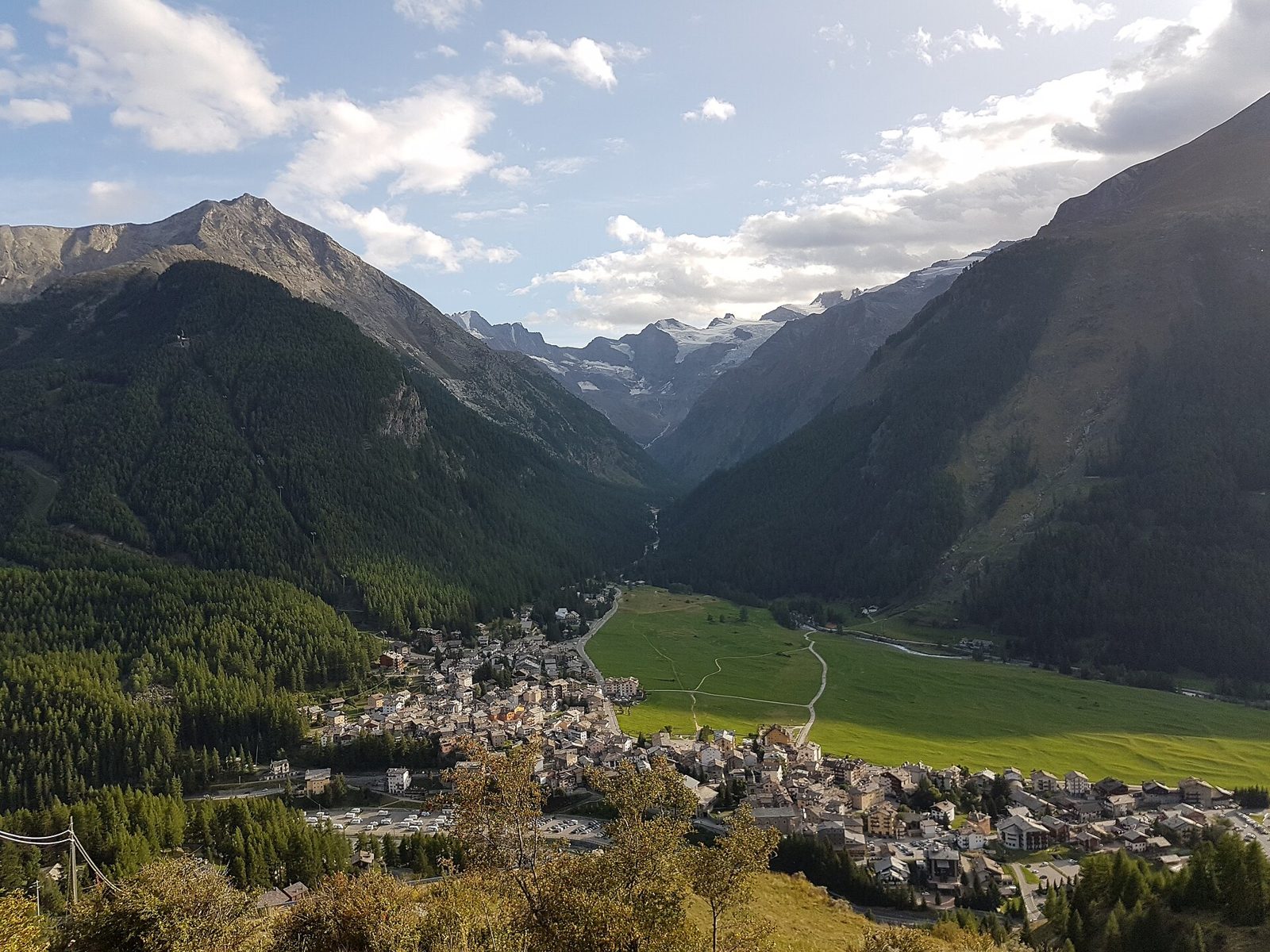 Panorama di Cogne con il prato di Sant'Orso e i ghiacciai del massiccio del Gran Paradiso sullo sfondo